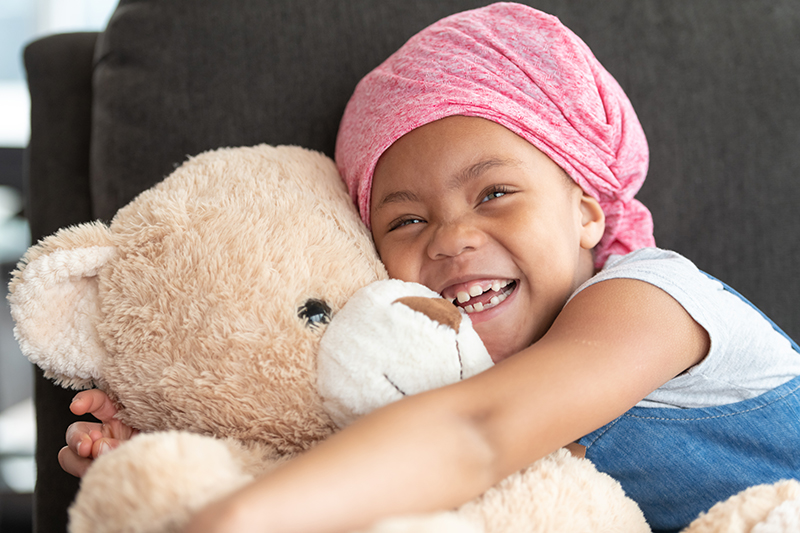 Happy girl hugs teddy bear